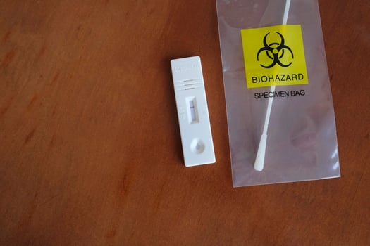 Coronavirus - COVID-19 - rapid test with negative result next to a nasal swab in a transparent bag with bio hazard photo