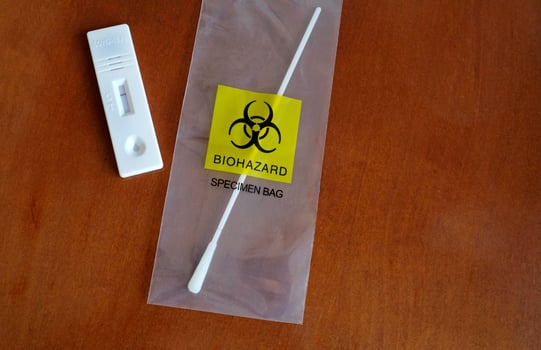 Coronavirus - COVID-19 - rapid test with negative result next to a nasal swab in a transparent bag with bio hazard photo