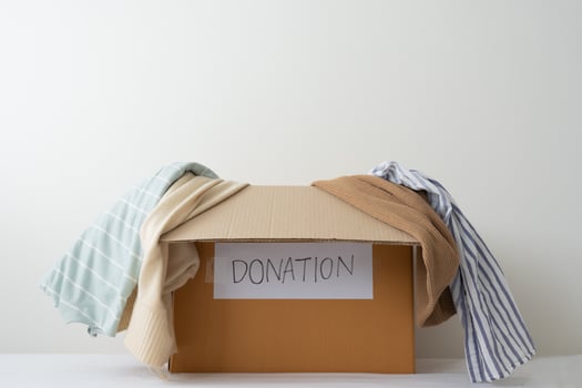 Clothing donation, Sharing, Hope concept. Used clothes on the carton donation box preparing to others photo