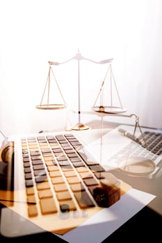Justice and law concept.Male judge in a courtroom with the gavel, working with, computer and docking keyboard, eyeglasses, on table in morning light photo