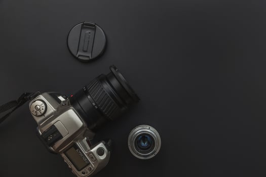 Photographer workplace with dslr camera system and lens on dark black table background. Hobby travel photography concept. Flat lay top view copy space. photo