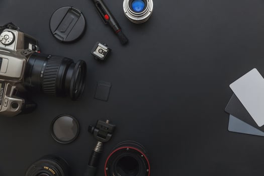 Photographer work place with dslr camera system, camera cleaning kit, lens and camera accessory on dark black table background. Hobby travel photography concept. Flat lay top view copy space. photo