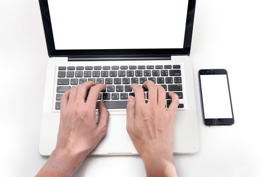 man typing on a laptop keyboard on white background, top view, hands close up photo