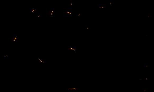 Burning red hot sparks fly from large fire in the night sky. Beautiful abstract background on the theme of fire, light and life. photo