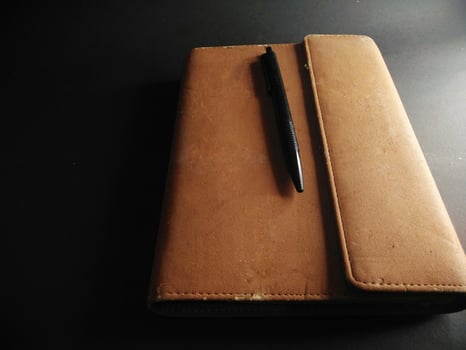 brown cover book on black background. painting light.close up. photo