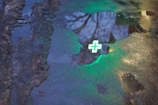 green cross reflection in rain puddle photo