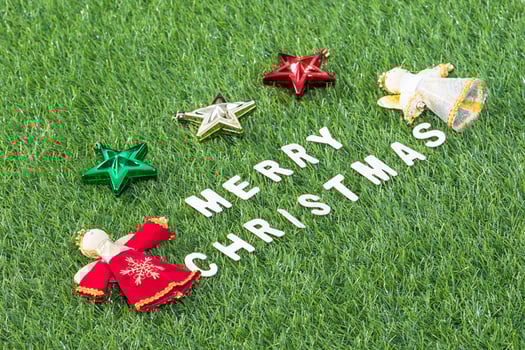 Top view Christmas alphabet and decoration on green grass photo