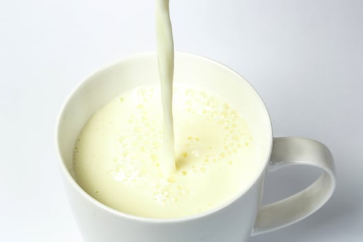 Pouring a cup of milk creating splash photo
