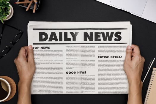 Hands holding Business Newspaper and office supplies with notebook, hot coffee cup, glasses, books and accessories on black desk topview, Daily Newspaper mockup concept photo