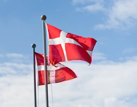 danish flags and white clouds in blue sky photo