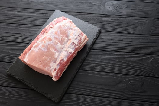 A large piece of pork loin on a rustic dark background. photo