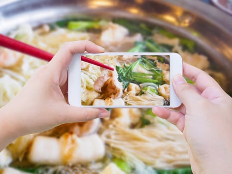 woman taking photo of sukiyaki shabu shabu