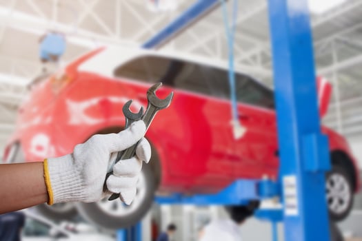 Car mechanic holding wrench at the car repair garage photo