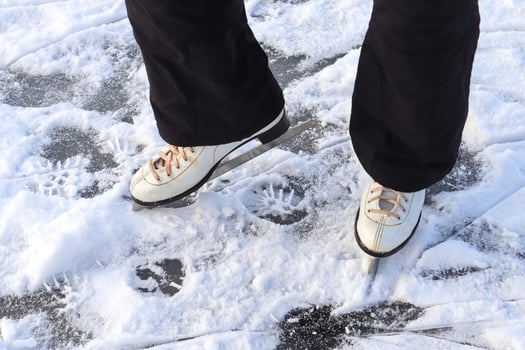 Close up on womans feet wearing ice skating boots and standing on ice. photo