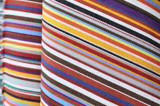 Detailed close up view on samples of cloth and fabrics in different colors found at a fabrics market photo