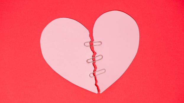 Shape of broken heart on red paper background. photo