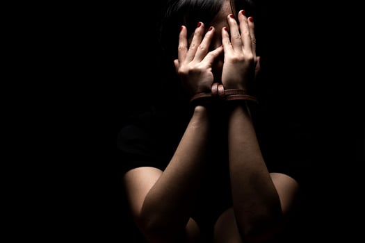 Woman tied up with leather belt in emotional stress and pain. Women's Day photo