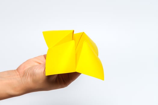 Hand in a paper fortune teller isolated on white background. photo