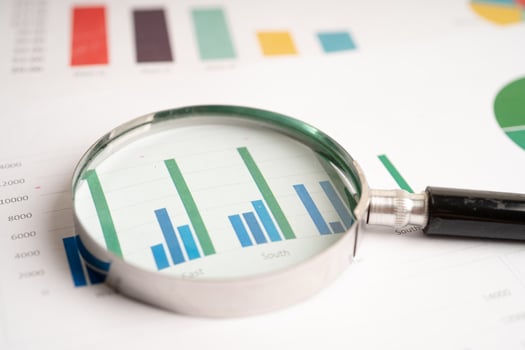 Magnifying glass on chart graph spreadsheet paper. Financial development, Banking Account, Statistics, economy, Stock exchange trading, Business office company meeting concept. photo