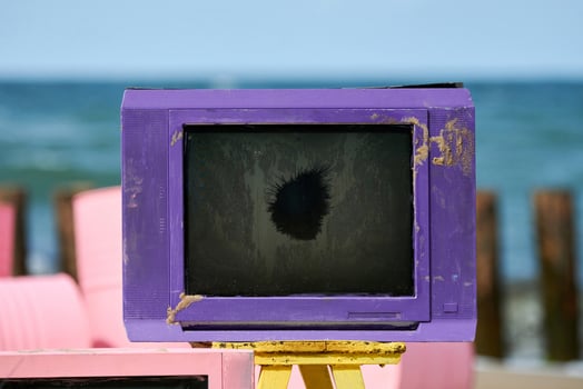 Old purple television with black broken screen on table, creative violet vintage TV-set. 80s, 90s photo