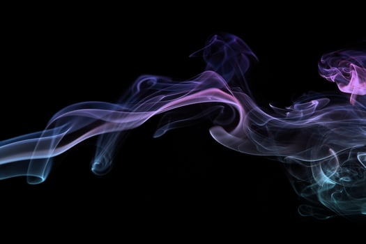 Multicolored smoke for aromatherapy relaxation on black background, beautiful swirled puffs of smoke photo