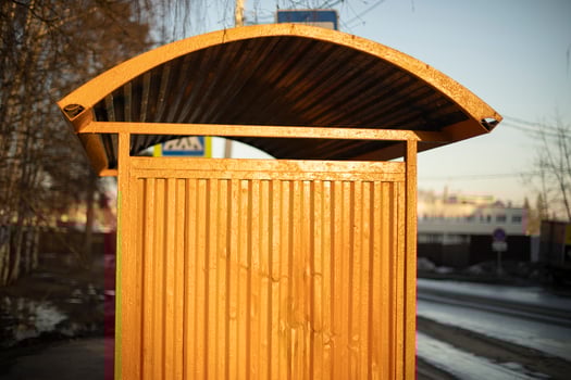 Yellow bus stop. Steel structure by road. photo