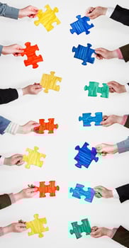 set painted puzzle pieces in people hands photo
