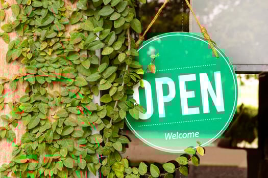 Hanging green sign with message OPEN on window with leaves ivy on wooden wall at coffee shop photo