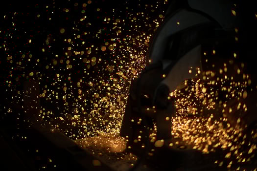Saw cuts metal. Sparks from friction. Lot of sparks from sawing steel. photo
