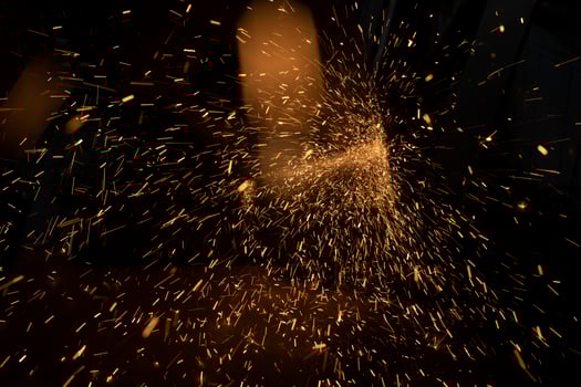 Sparks from grinder. Metal cutting. Bright lights in dark. Industrial background. photo