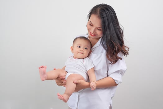 Safe in his mother's arms. Mother and her baby girl at home. photo