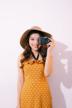 portrait of smiling young girl in hat with camera posing isolated on a pastel background photo
