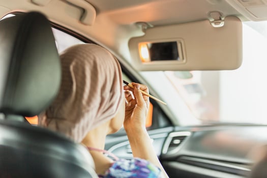 Woman enjoy while makeup herself in the car. photo