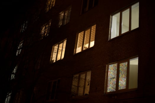 Windows in night city. Light of windows in house. Residential apartments in dark. photo