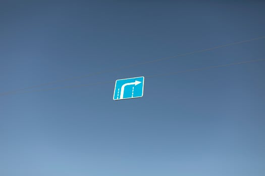 Right turn sign. Road sign over road. Blue sign with arrow against sky. photo