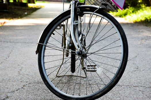 Closeup view of rear flat tire of vintage bicycle which parked on pavement beside the road. soft and selective focus. photo