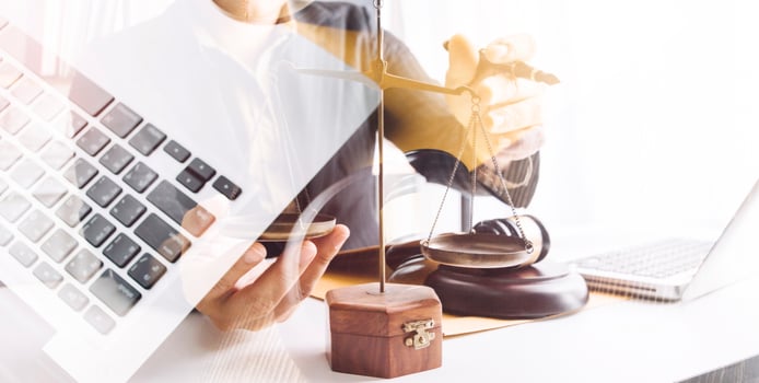 Justice and law concept.Male judge in a courtroom with the gavel, working with, computer and docking keyboard, eyeglasses, on table in morning light photo