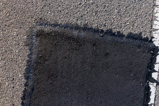 The repaired part of an asphalt road with patches photo
