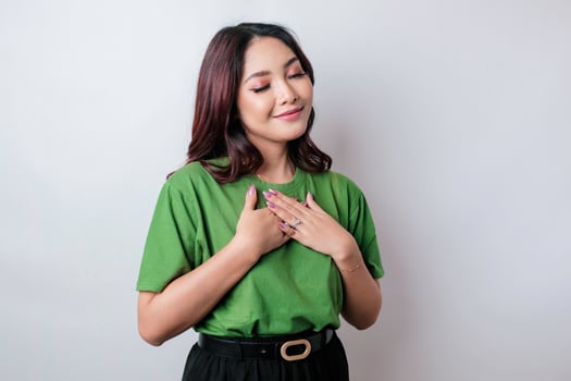 Happy mindful thankful young woman hand on chest smiling isolated on white background photo