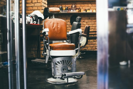 Stylish Vintage Barber Chair In brick wall Interior. Barbershop Theme. Barbershop armchair. Modern hairdresser and hair salon, barber shop for men. photo