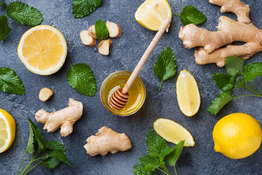 Lemon honey and ginger root mint on dark grey background with copy space. Ingredients for a tonic vitamin drink. photo