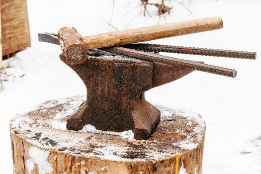 anvil with blacksmith tongs hammer in smithy photo