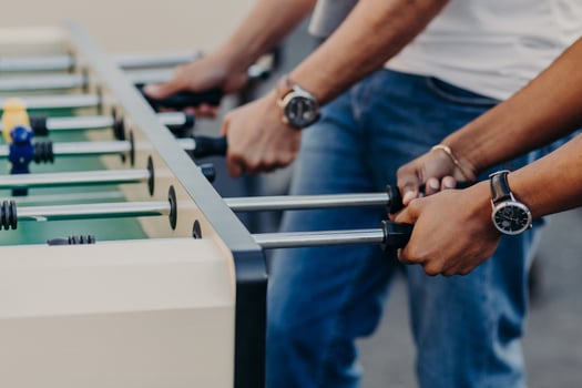 People enjoy playing soccer game, play table football, enjoy recreation time. Mini game. Leisure and activities concept. Entertainment concept photo