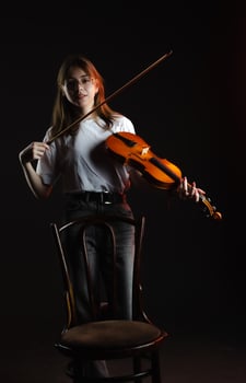 a girl with a violin on a dark background, wearing a white T-shirt photo