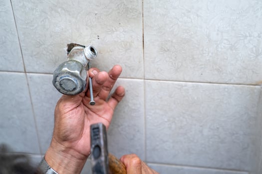 Asian man tries to fix and repair pipe shower in the old restroom. photo
