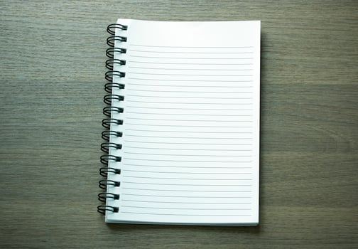 blank spiral notebook on dark wood background photo