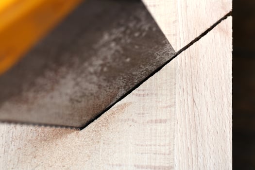 wooden board is cut with hacksaw photo