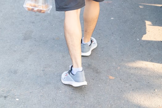 Backside view of person which walk on the concrete road. photo