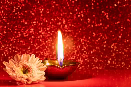 Happy Diwali. Burning diya oil lamps and flowers on red glittering background. Celebrating the traditional Indian festival of light. photo