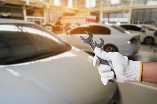 mechanic holding wrench over car repair service centre photo